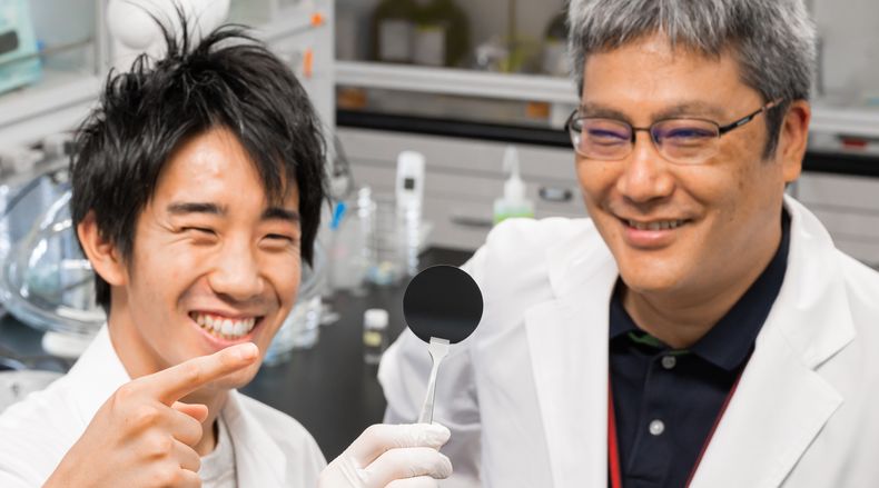 Shigenori Fujikawa and student hold up CO2 filter membrane