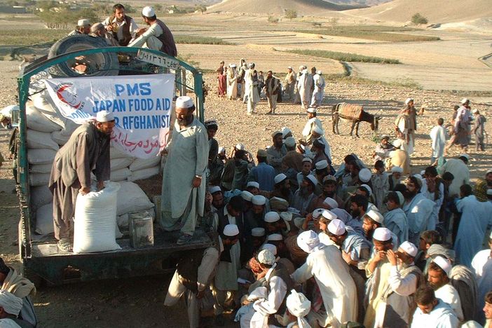 Peace (Japan) Medical Services (PMS) distributing food to people in Afghanistan. Photograph courtesy of Peshawar-kai/PMS.
