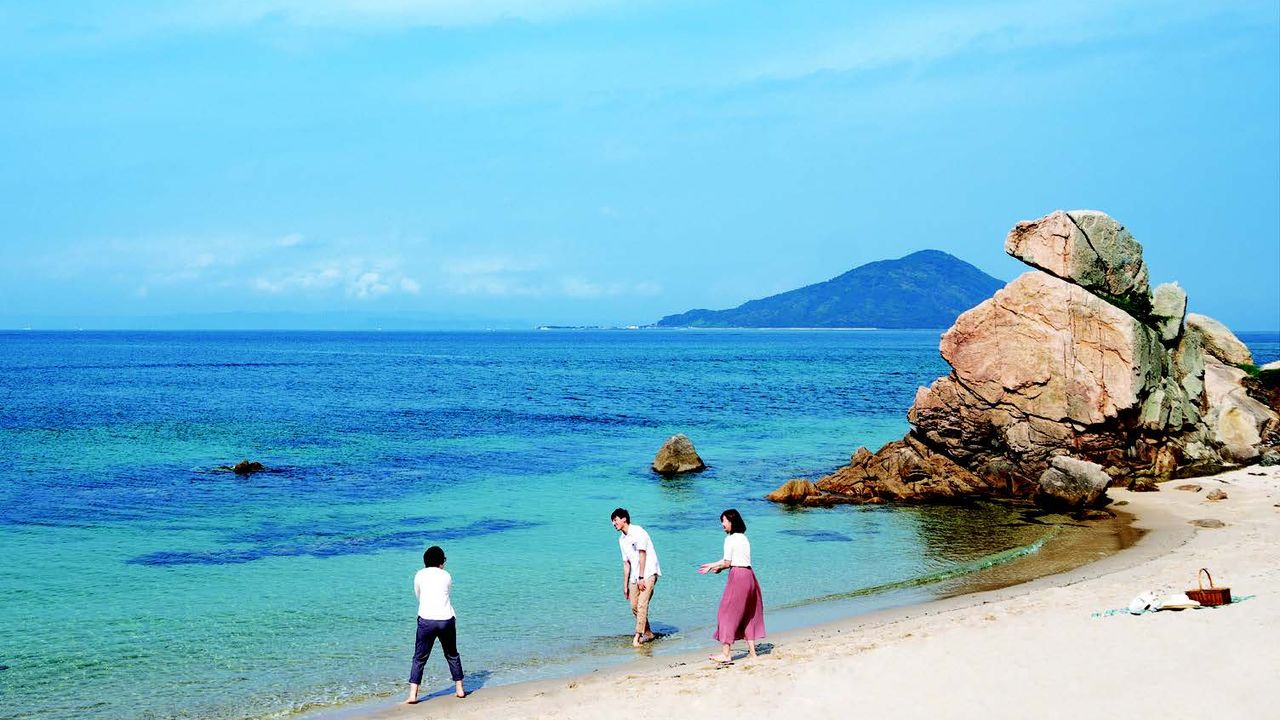 Students play on a beach in Itoshima