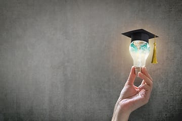 A lightbulb with a graduation cap on top