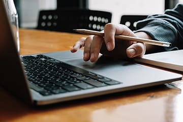 A hand works on a computer